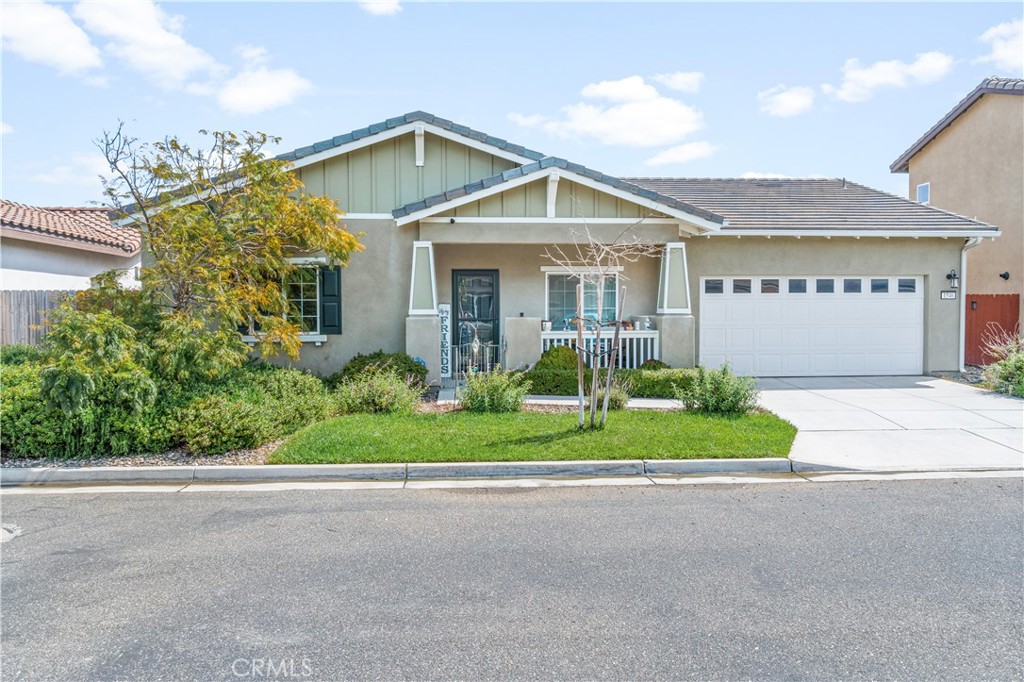 a front view of a house with a yard and plants