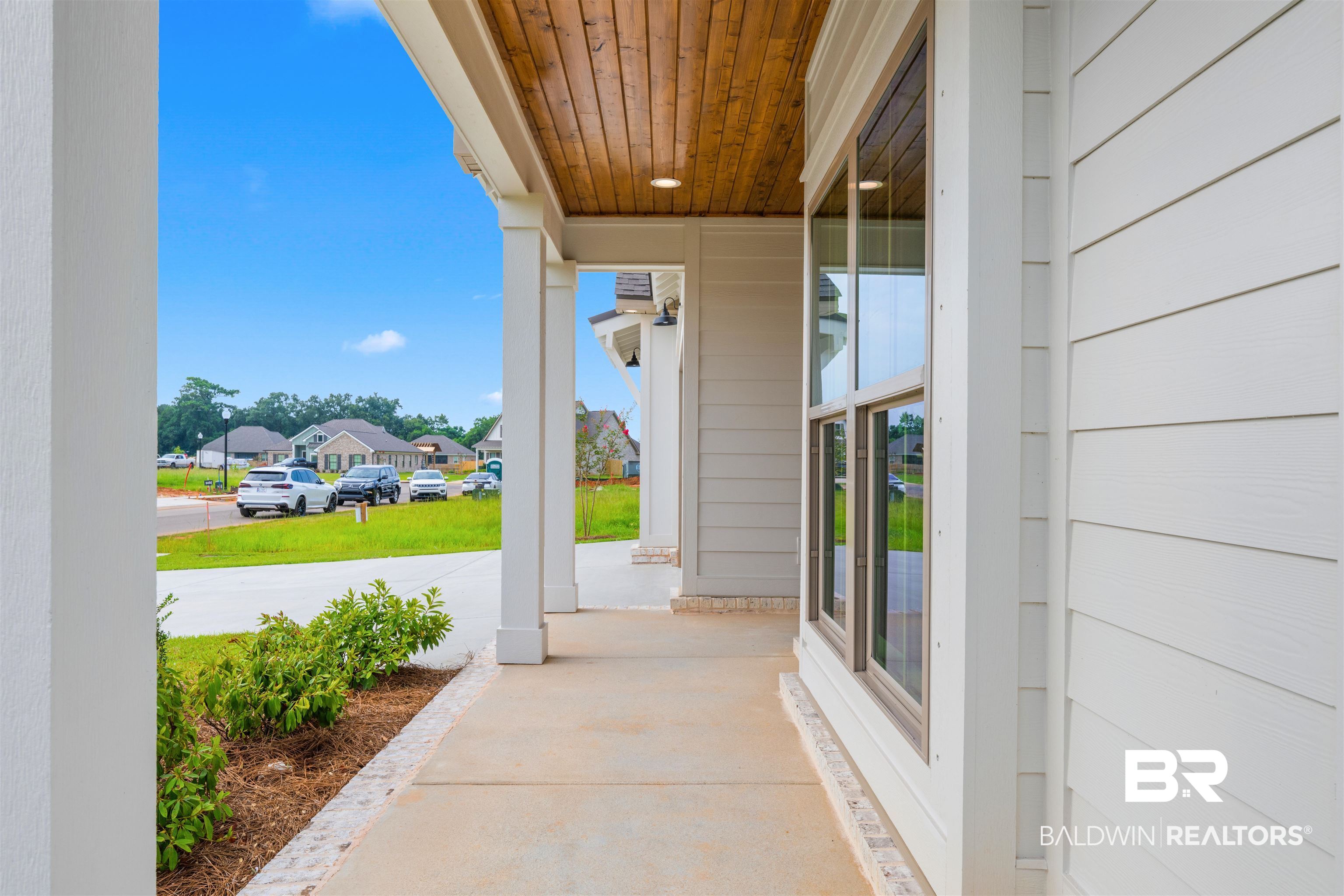 27494 Patch Pl Loop Daphne, AL 36526 - Photo 5 of 26 Covered front porch featuring a wood-finish ceiling, recessed lighting, white columns, and concrete flooring