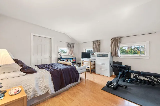 a bedroom with a bed a large window and chair