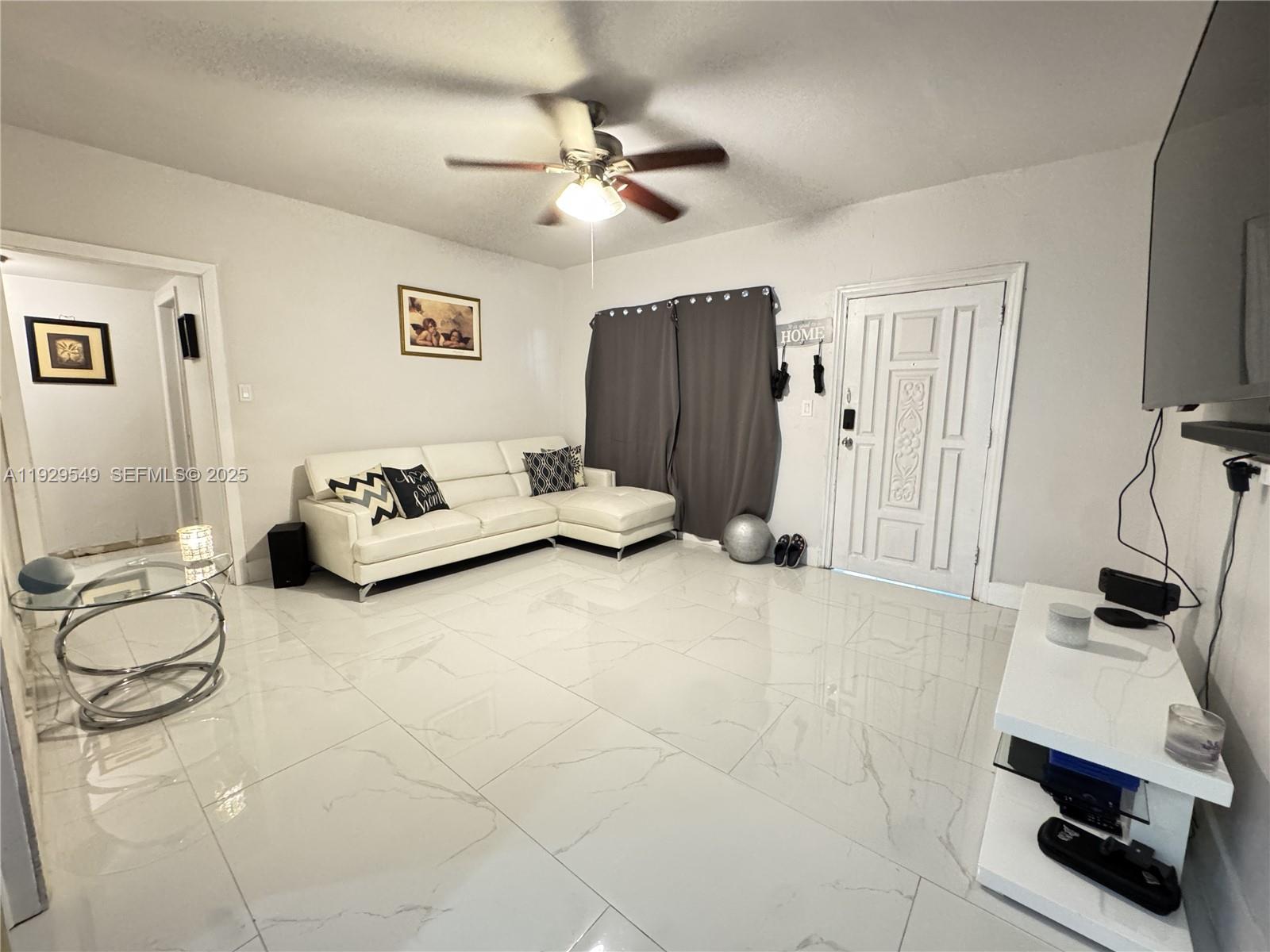 343 West 42nd Street, Unit A Hialeah, FL 33012 - Photo 3 of 13 a living room with furniture and a flat screen tv
