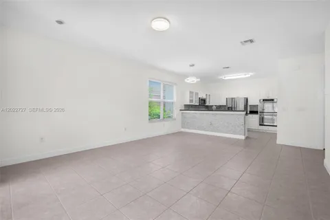 a view of a kitchen with a sink and a refrigerator