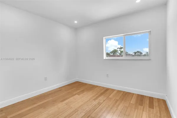 a view of empty room with wooden floor