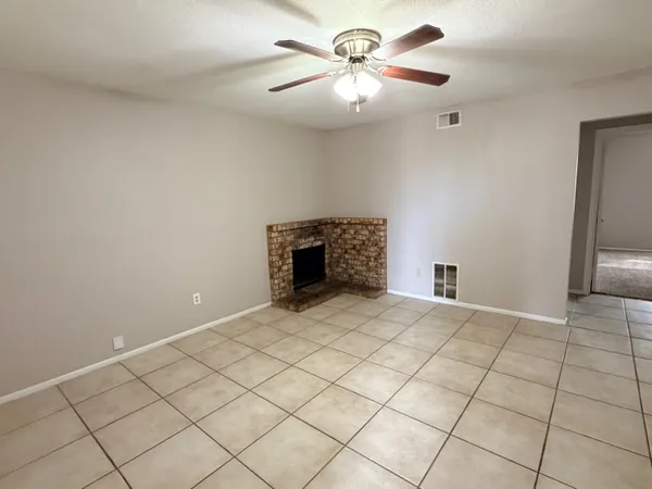 an empty room with fireplace and fan
