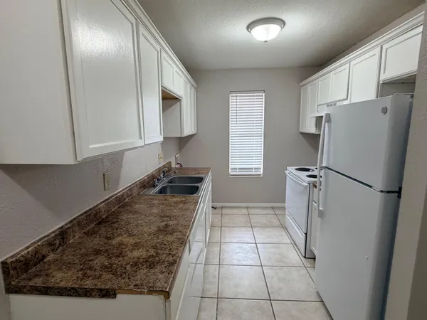 a kitchen with granite countertop a refrigerator and a stove