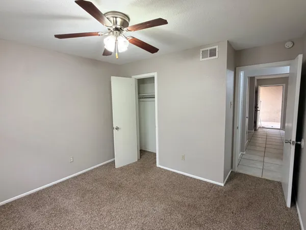 an empty room and chandelier fan