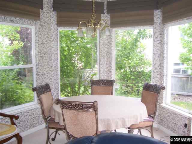 4890 West Creek Ridge Trail Reno, NV 89519 - Photo 2 of 9 a view of a patio with table and chairs potted plants with floor to ceiling window