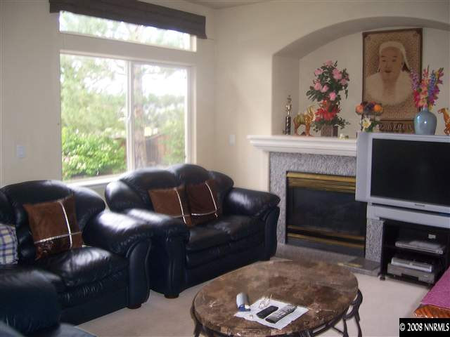 4890 West Creek Ridge Trail Reno, NV 89519 - Photo 3 of 9 a living room with furniture a window and a fireplace