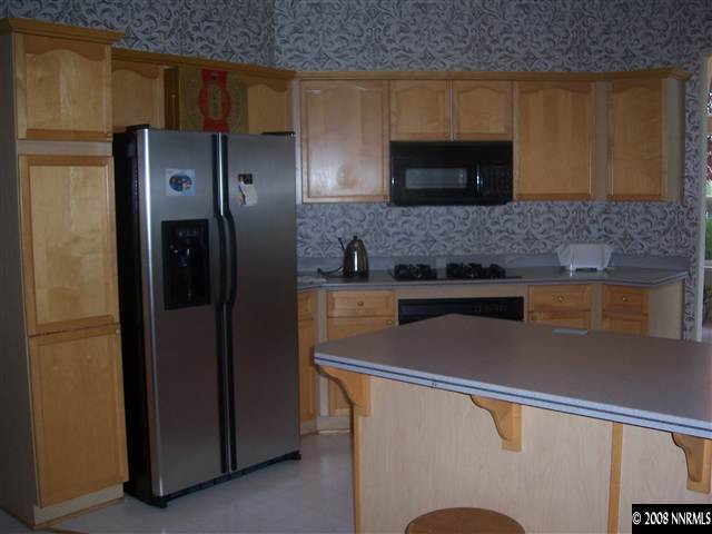 4890 West Creek Ridge Trail Reno, NV 89519 - Photo 6 of 9 a kitchen with stainless steel appliances a refrigerator and a sink