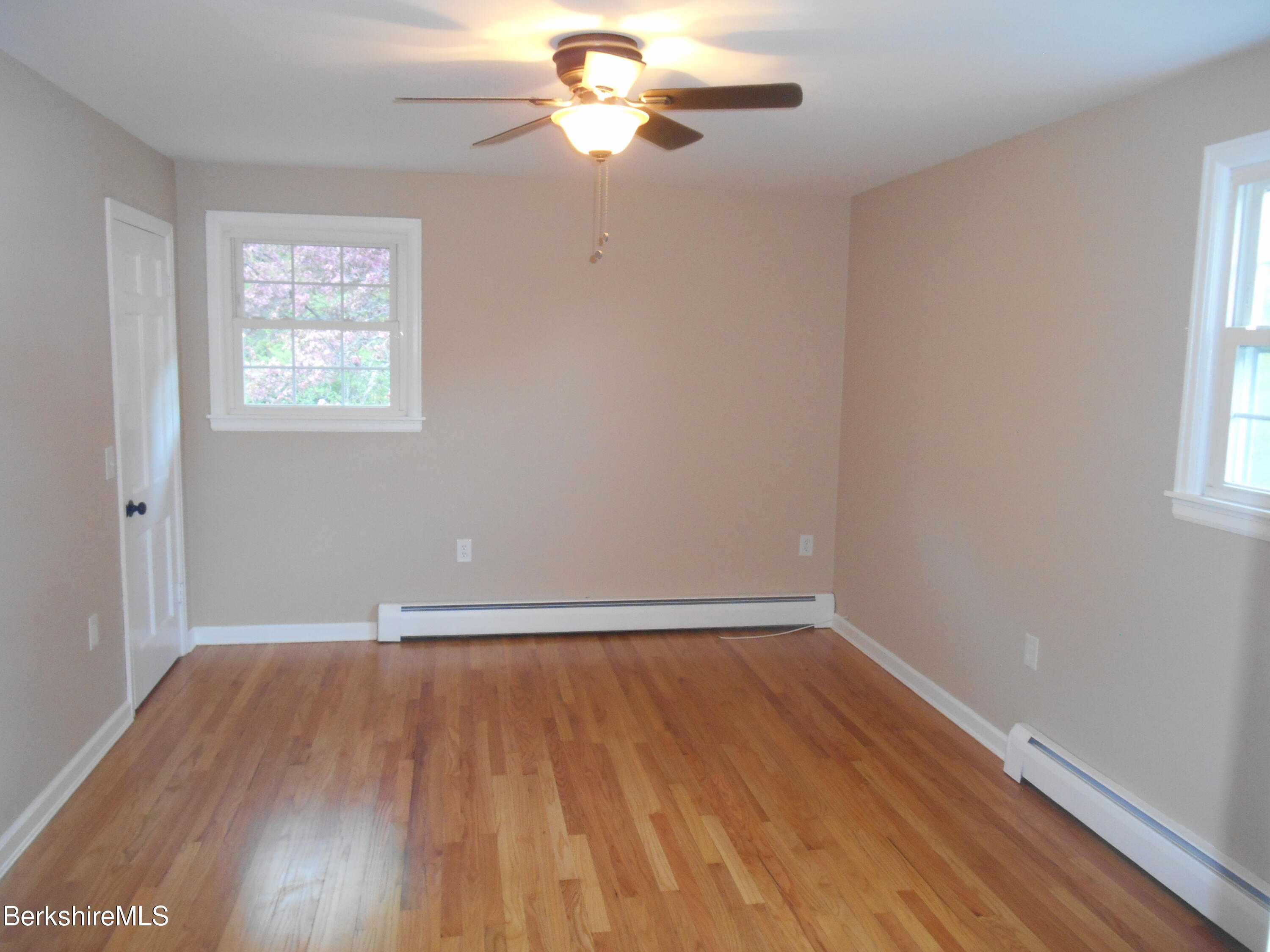 238 Swamp Road Richmond, MA 01201 - Photo 15 of 21 an empty room with wooden floor chandelier fan and windows