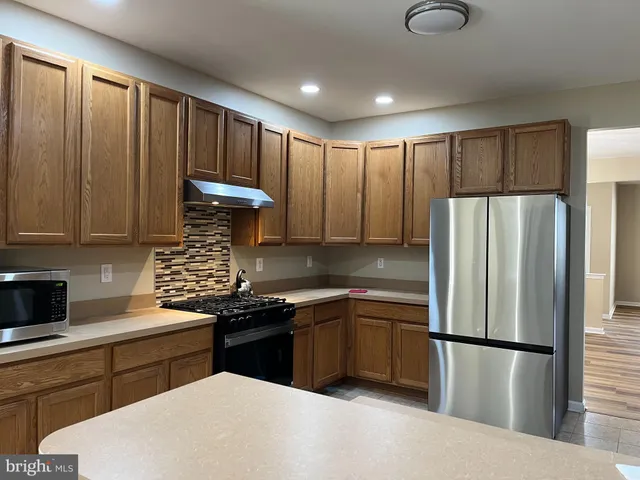 a kitchen with a sink a refrigerator and cabinets