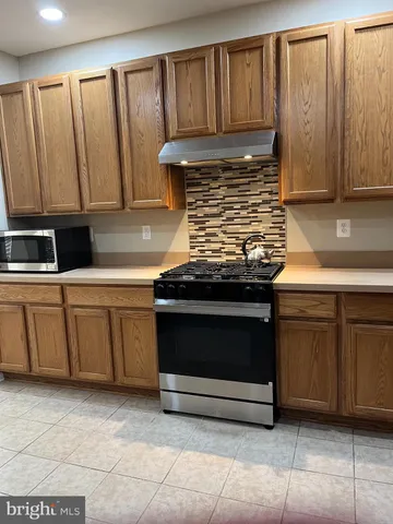 a stove top oven sitting inside of a kitchen