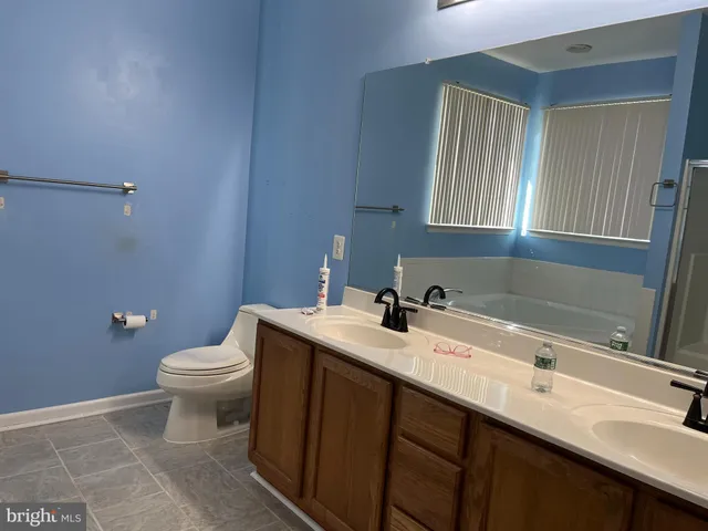 a bathroom with a granite countertop sink a toilet and a bathtub