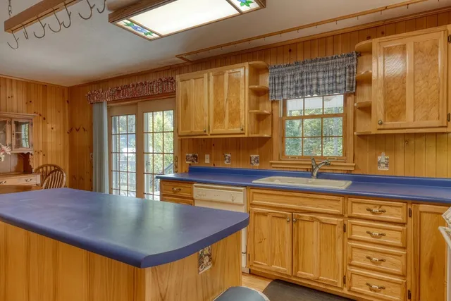 a kitchen with stainless steel appliances granite countertop a stove a sink dishwasher and cabinets with wooden floor