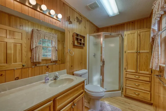 a bathroom with a granite countertop sink toilet and shower