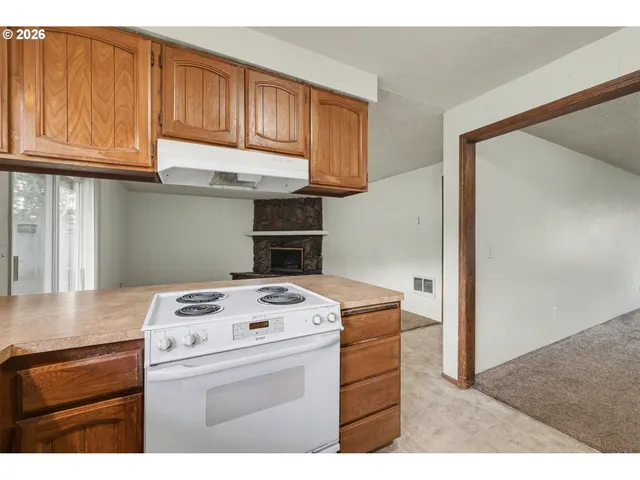 a kitchen with stainless steel appliances granite countertop a refrigerator a sink a stove with wooden cabinets