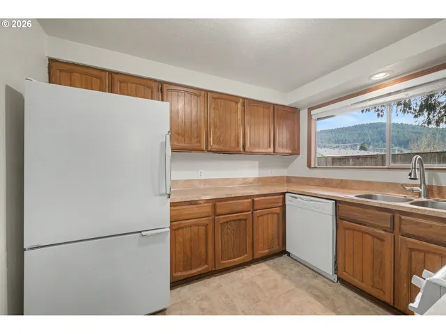 a kitchen with stainless steel appliances a stove a sink and a refrigerator