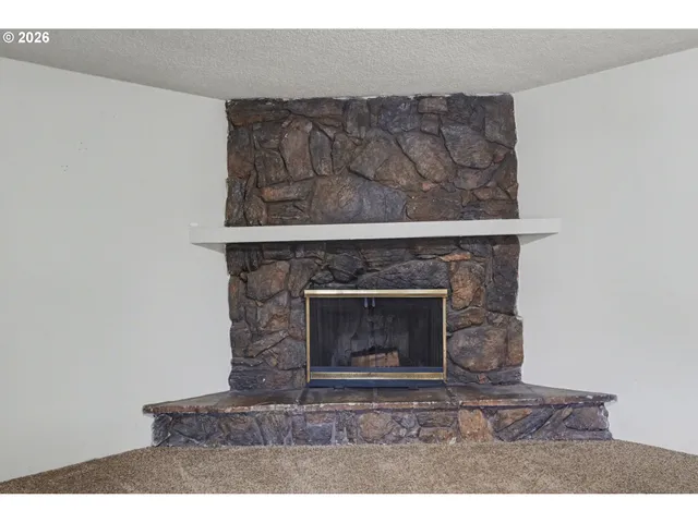 a view of an empty room with a fireplace and a window
