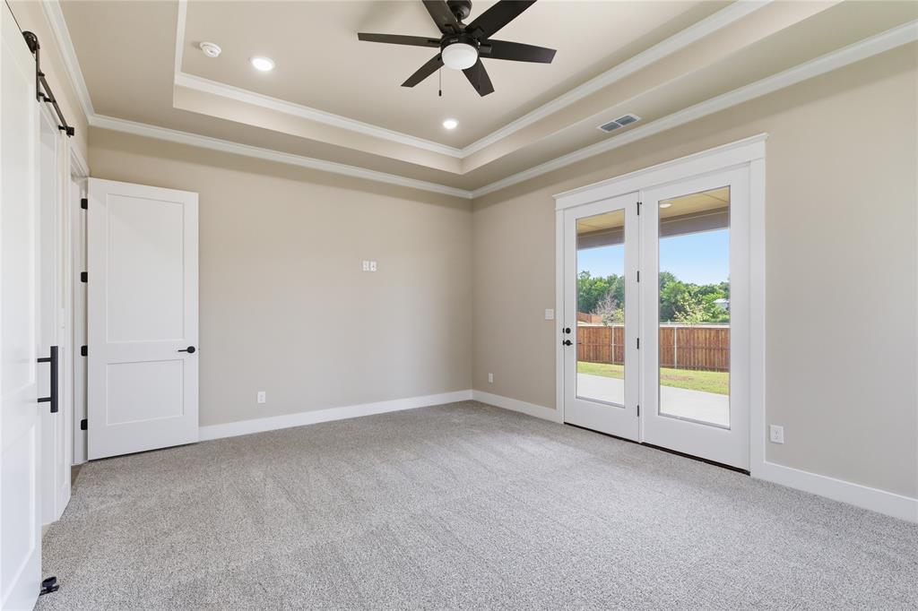 709 Anne Road Van Alstyne, TX 75495 - Photo 19 of 28 Spacious room featuring light gray carpet flooring, tray ceiling with recessed lighting, and a ceiling fan