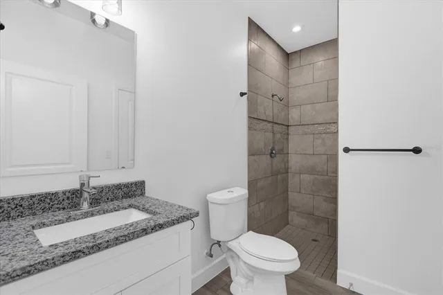 a bathroom with a granite countertop sink toilet and shower