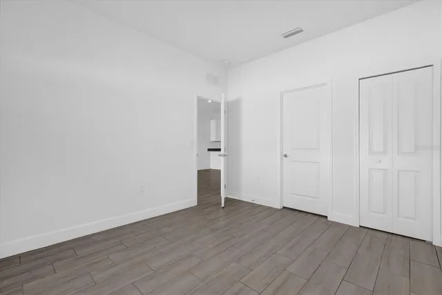 an empty room with wooden floor and white walls