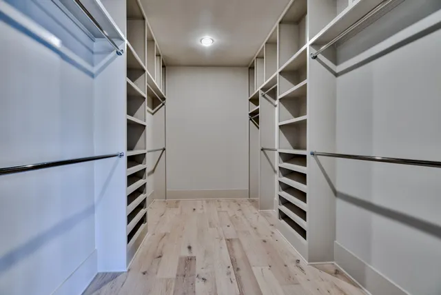 an empty walk in closet with wooden floor