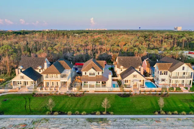 an aerial view of residential houses with outdoor space and ocean view