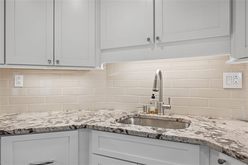 5 Bayard Road, Unit 219 Pittsburgh, PA 15213 - Photo 9 of 26 Bright white cabinetry and under-cabinet lighting beautifully illuminate the updated countertops, creating a timeless kitchen designed for both everyday living and entertaining.