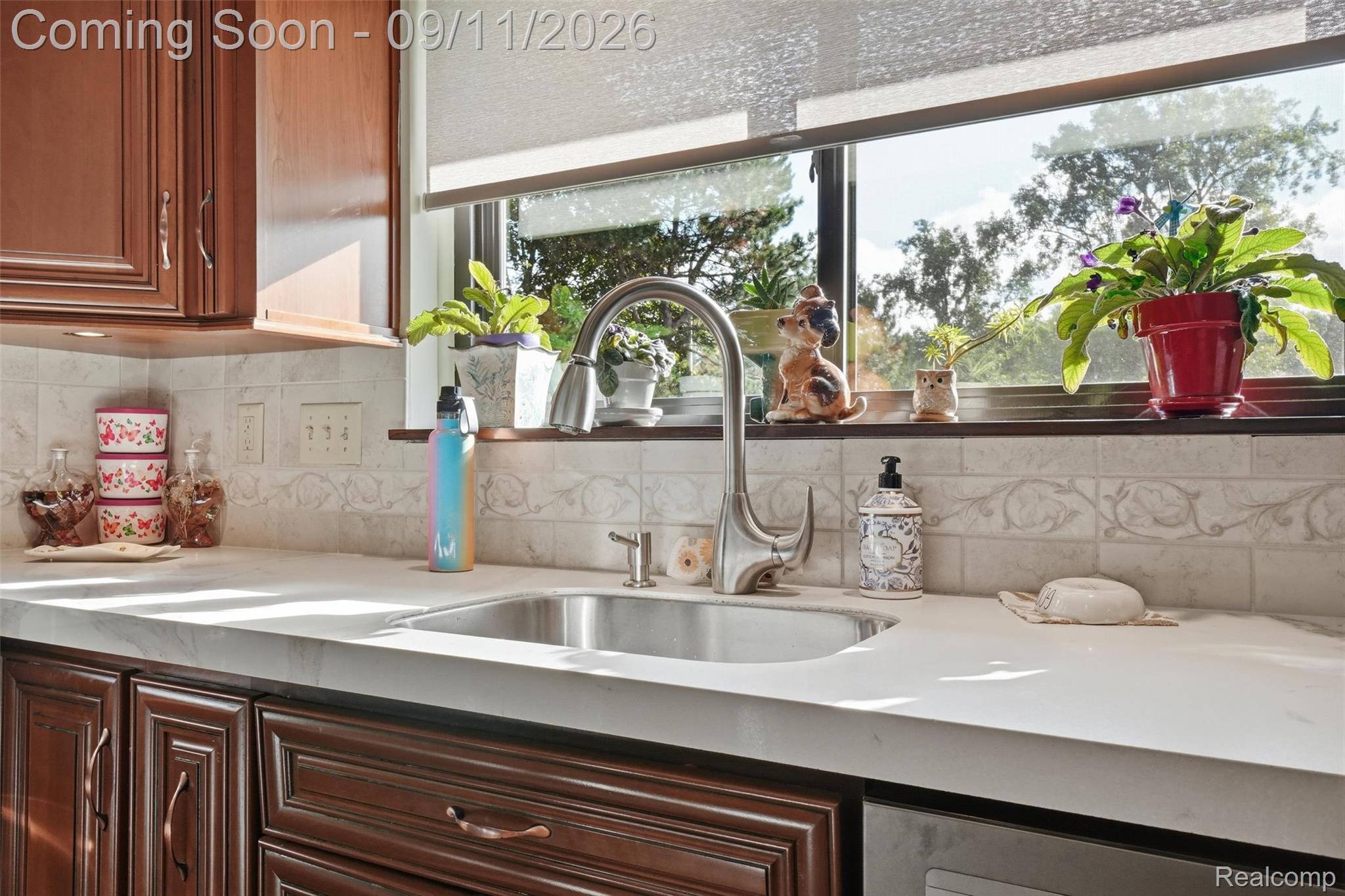 16799 Farmington Road Livonia, MI 48154 - Photo 15 of 71 Undermount stainless steel sink with a high-arch chrome faucet, complemented by light-toned countertops and a decorative tile backsplash