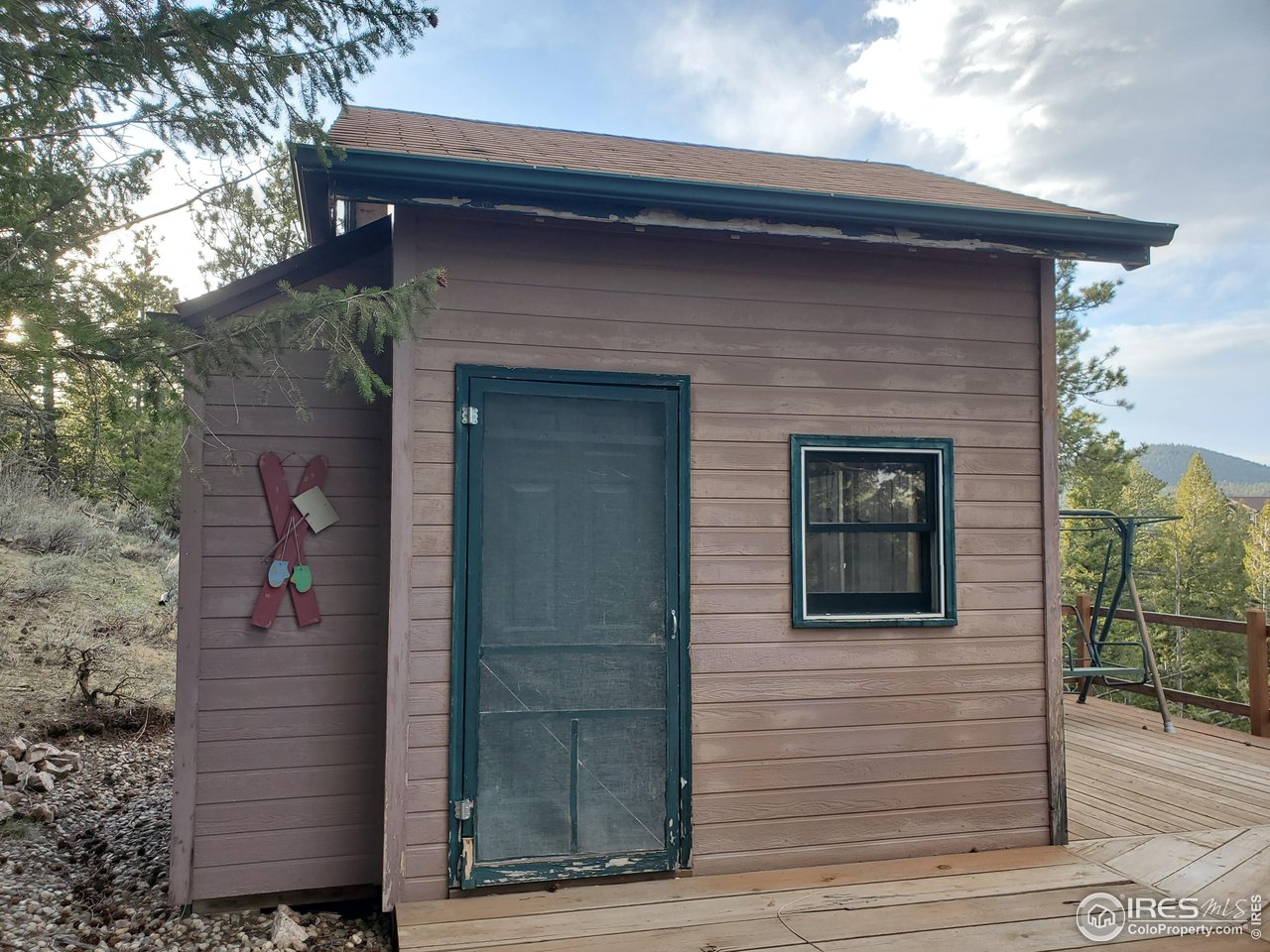 1375 Crow Road Red Feather Lakes, CO 80545 - Photo 13 of 17 a front view of a house with glass windows and brick walls