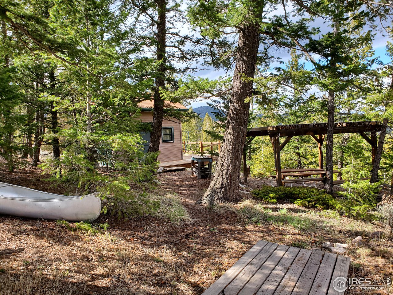 1375 Crow Road Red Feather Lakes, CO 80545 - Photo 5 of 17 a backyard of a house with table and chairs