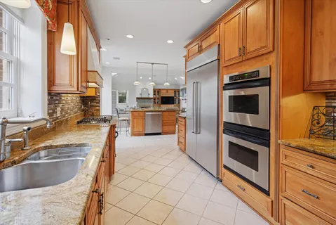 a dining hall with stainless steel appliances a dining table chairs and view living room