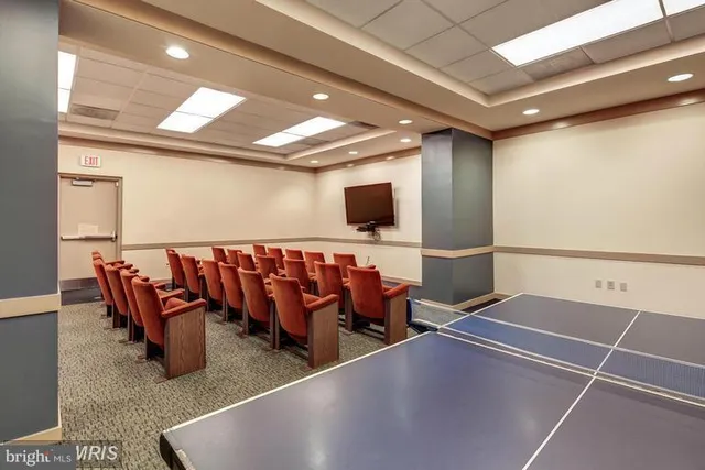 a living room with a flat screen tv and chairs