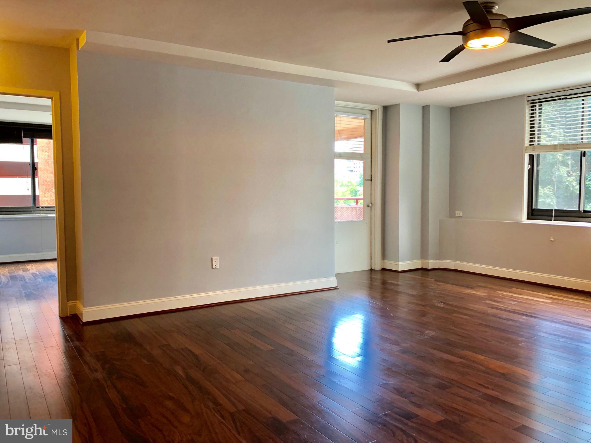 1021 Arlington Boulevard, Unit 706 Arlington, VA 22209 - Photo 4 of 24 a view of an empty room with wooden floor and a window