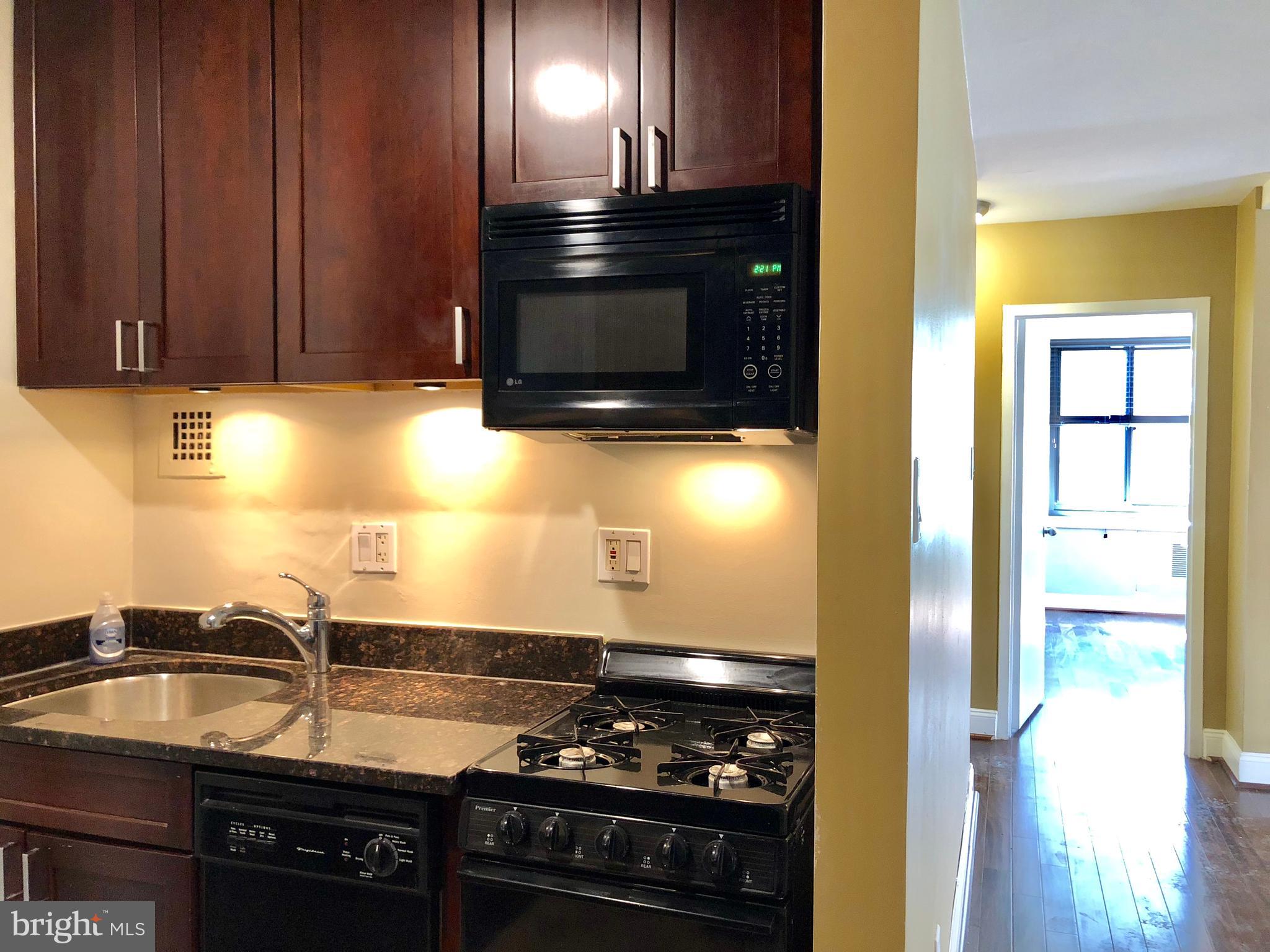 1021 Arlington Boulevard, Unit 706 Arlington, VA 22209 - Photo 6 of 24 a kitchen with granite countertop a stove and a refrigerator