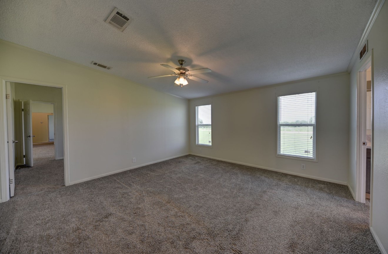 10901 Harmon School Road Burton, TX 77835 - Photo 13 of 23 an empty room with windows and ceiling fan