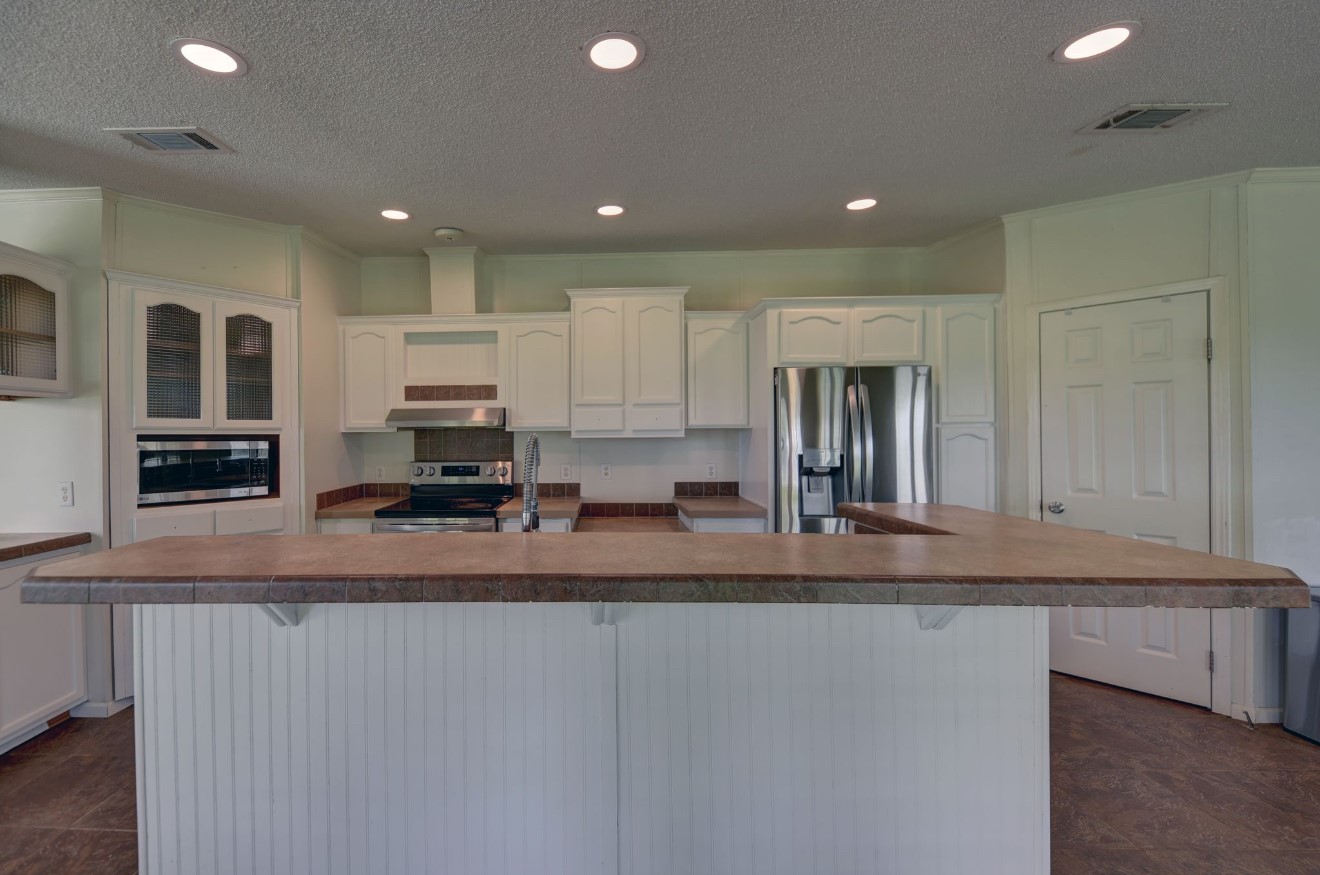 10901 Harmon School Road Burton, TX 77835 - Photo 4 of 23 a view of a kitchen with kitchen island a counter top space a sink and stainless steel appliances