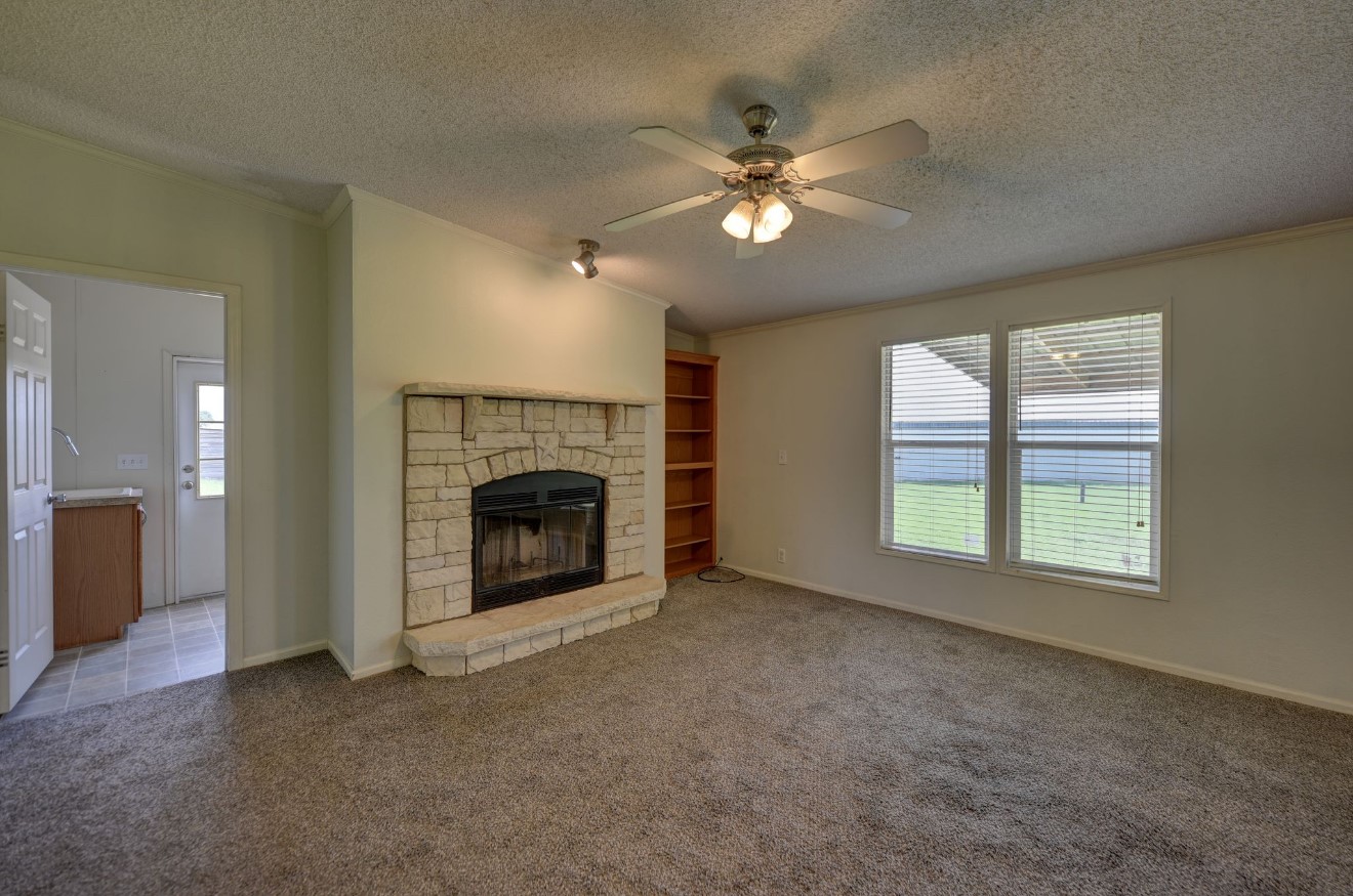 10901 Harmon School Road Burton, TX 77835 - Photo 6 of 23 a view of a livingroom with a fireplace and a window