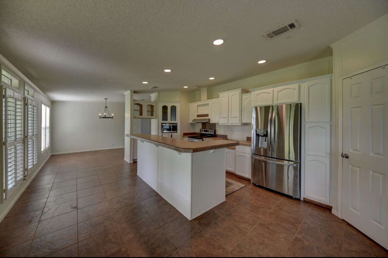10901 Harmon School Road Burton, TX 77835 - Photo 7 of 23 a kitchen with refrigerator and cabinets