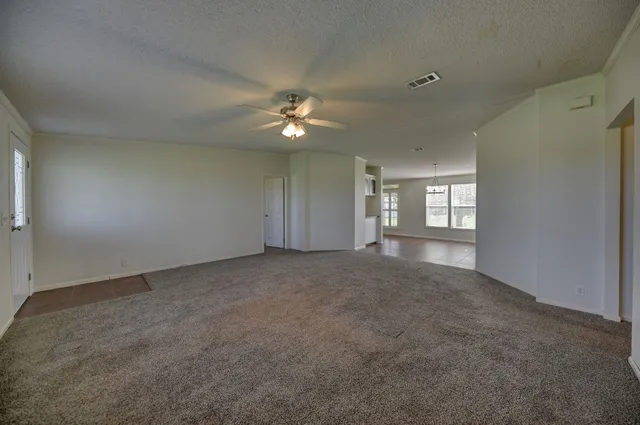 an empty room with closet and a ceiling fan