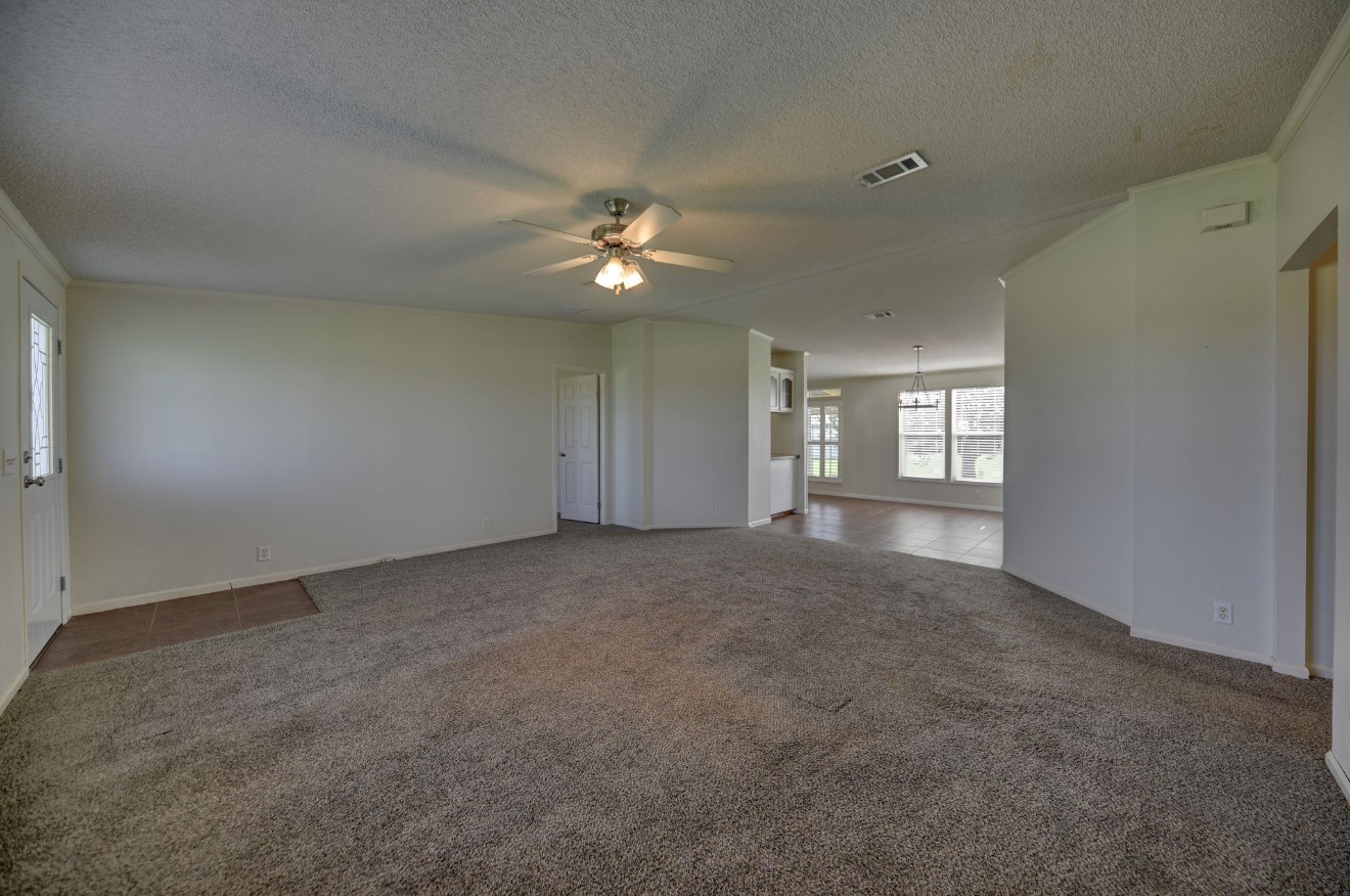 10901 Harmon School Road Burton, TX 77835 - Photo 9 of 23 a view of a big room with windows and chandelier fan