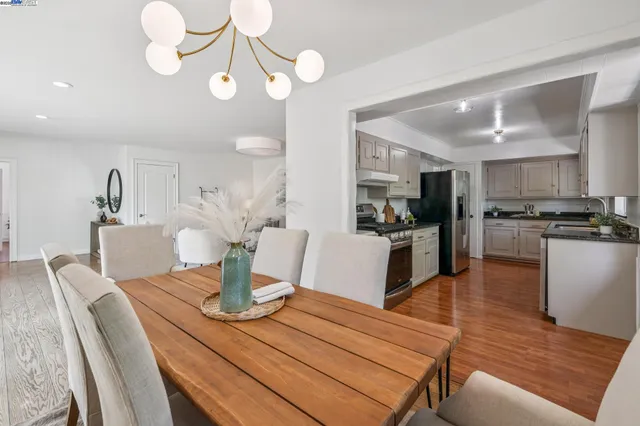 a kitchen with a table chairs microwave and cabinets