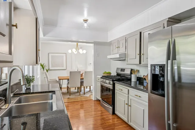 a kitchen with stainless steel appliances granite countertop a sink a stove and refrigerator