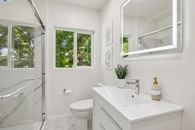 a bathroom with a sink toilet and a mirror