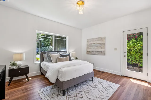 a bedroom with a bed lamp on table and a window