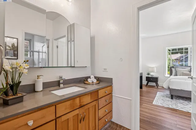 a en suite bathroom with a granite countertop sink and a mirror