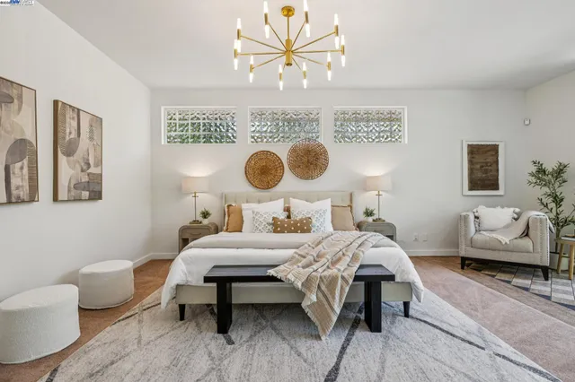 a bedroom with a bed and a chandelier