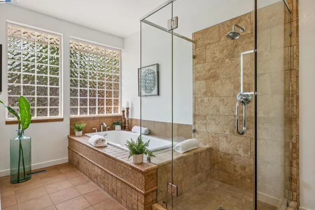 a bathroom with a tub shower and window