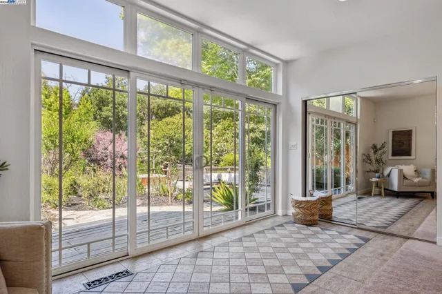 a living room filled with furniture and large windows