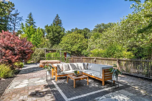 a view of a patio with table and chairs and potted plants with wooden floor and fence