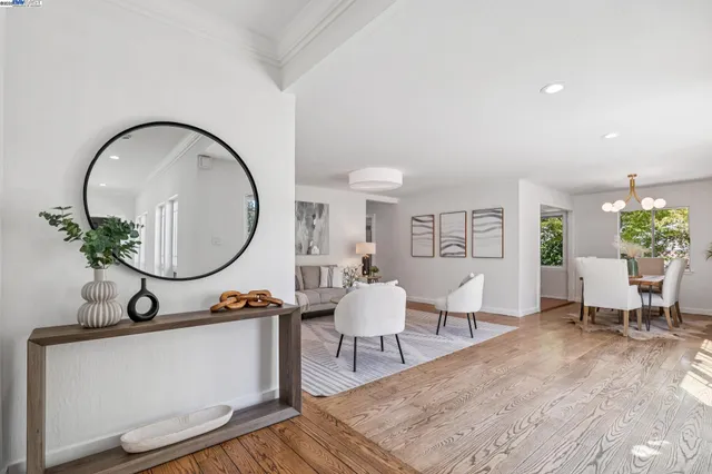 a living room with furniture a mirror and a potted plant